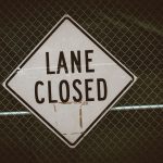 a close up of a street sign on a fence