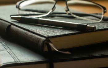 silver framed eyeglasses on black book