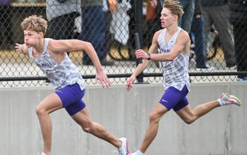 Nash Delger, right, hands off to Zach Stene as the Lake Mills Bulldogs took first place in the distance medley relay at Nevada. (Submitted photo)